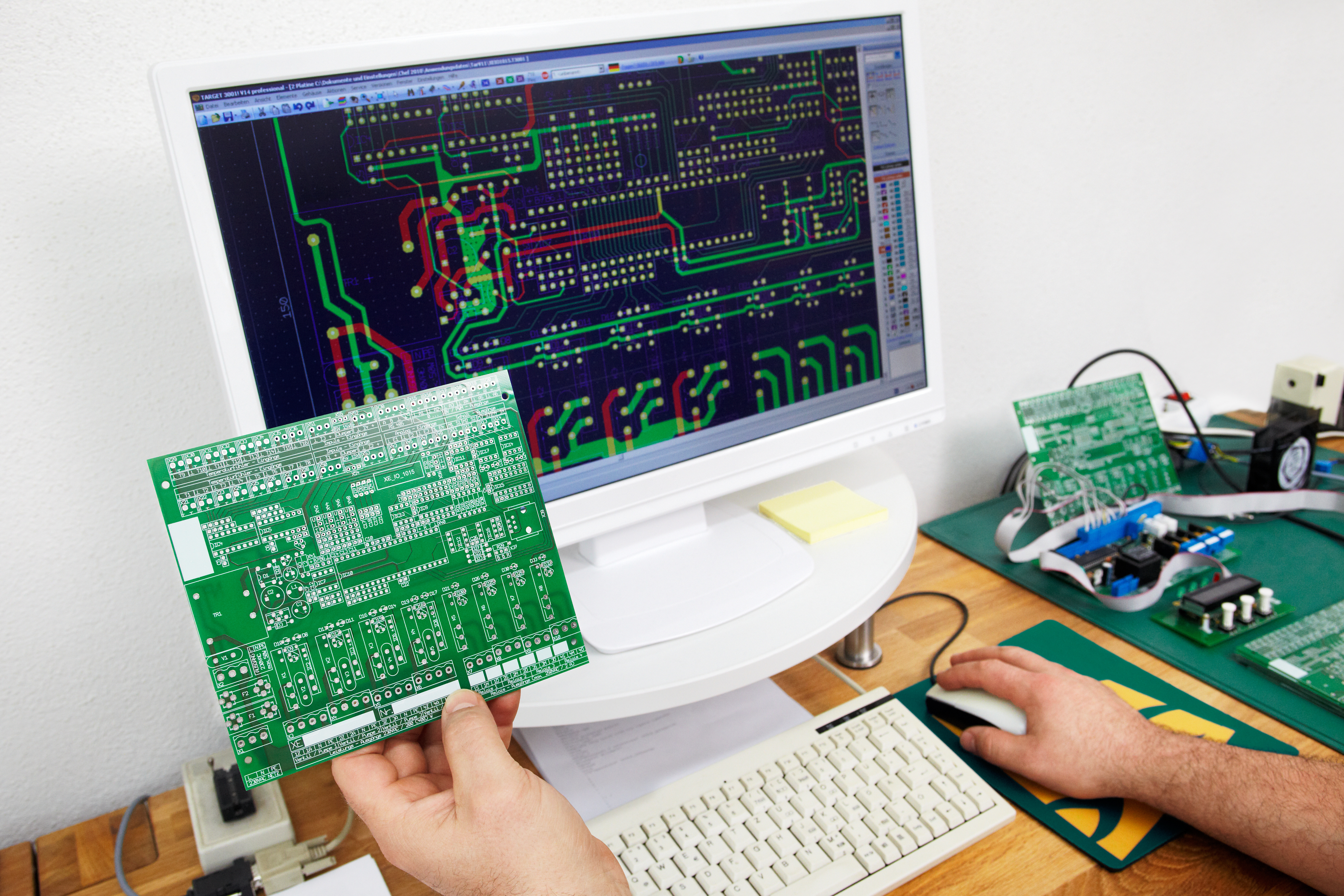 PCB Designer reviewing a PCB against a schematic