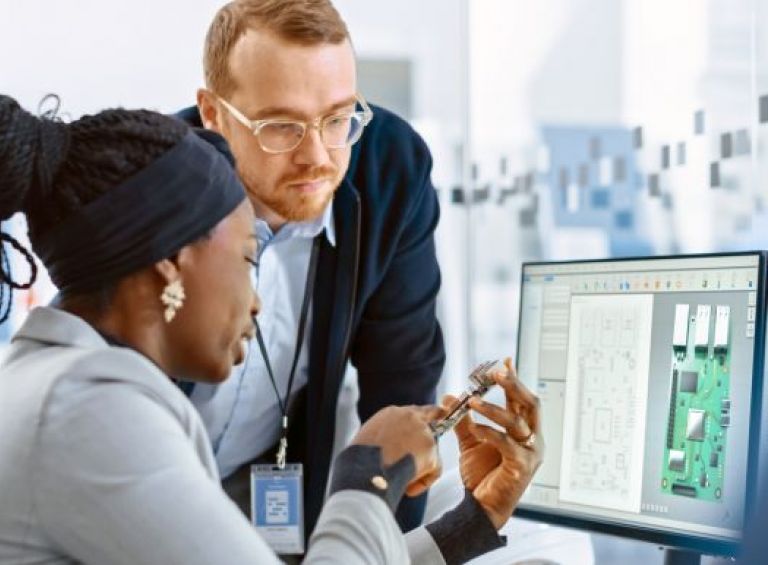 Two people working on the computer together