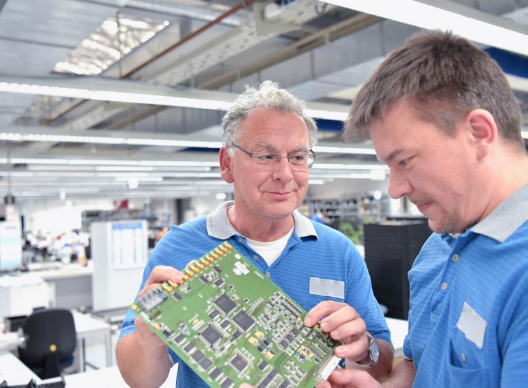 Trainer showing a trainee a PCB